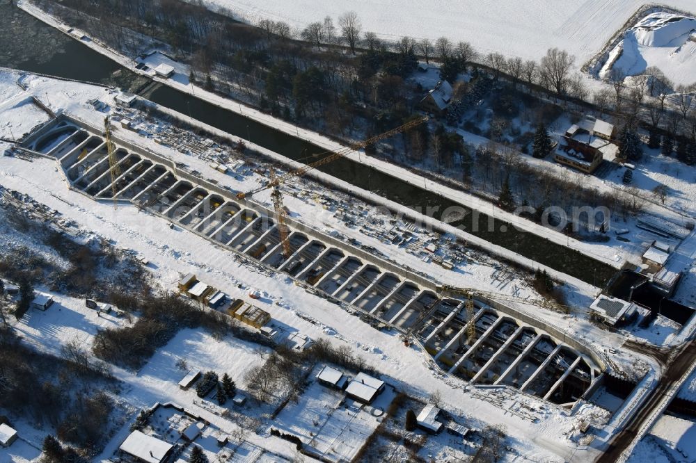 Zerben from the bird's eye view: Wintry snowy construction site at the Zerben sluice, bridge and the riverside of the Elbe-Havel-Canel in the state Saxony-Anhalt