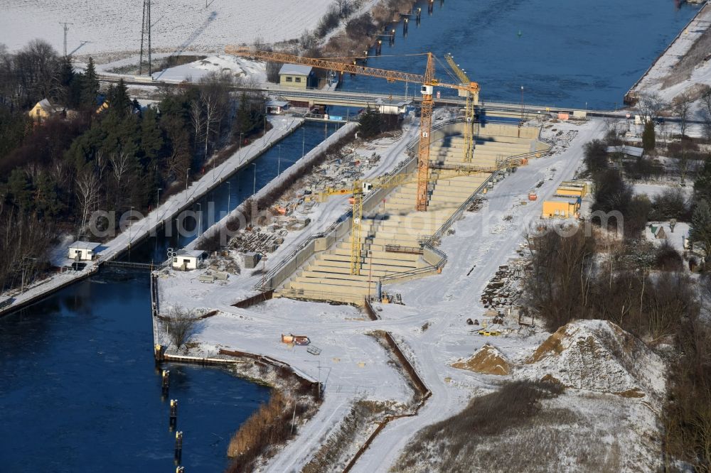 Zerben from the bird's eye view: Wintry snowy construction site at the Zerben sluice, bridge and the riverside of the Elbe-Havel-Canel in the state Saxony-Anhalt