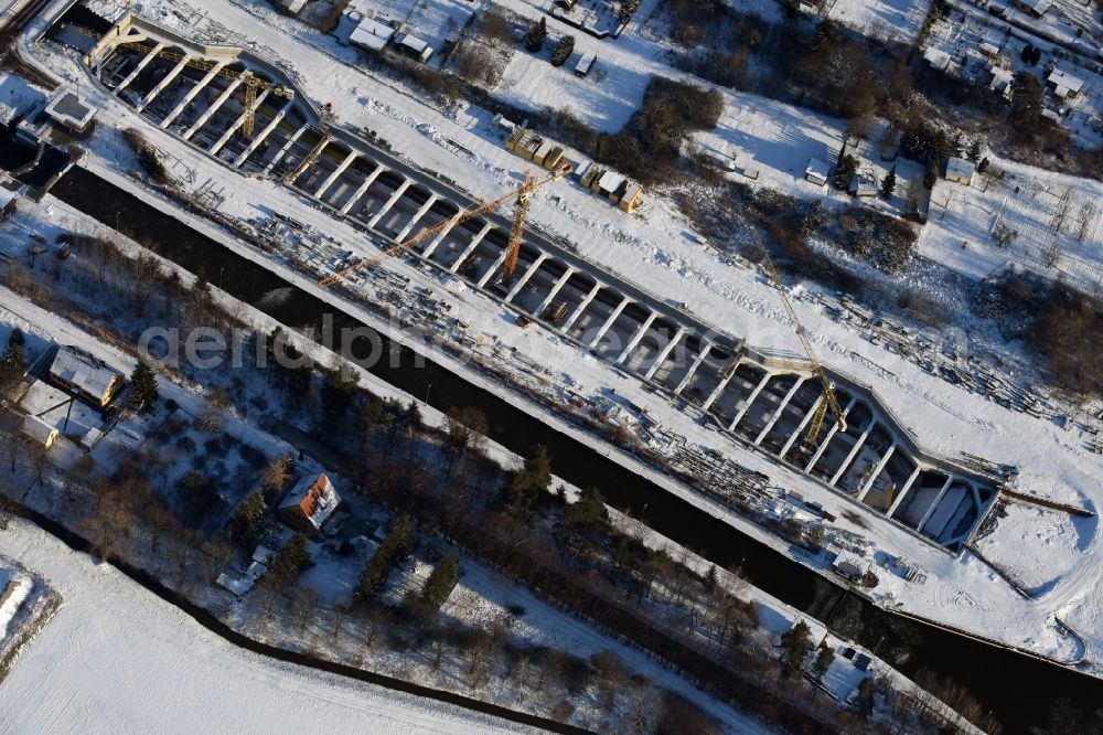 Zerben from the bird's eye view: Wintry snowy construction site at the Zerben sluice, bridge and the riverside of the Elbe-Havel-Canel in the state Saxony-Anhalt