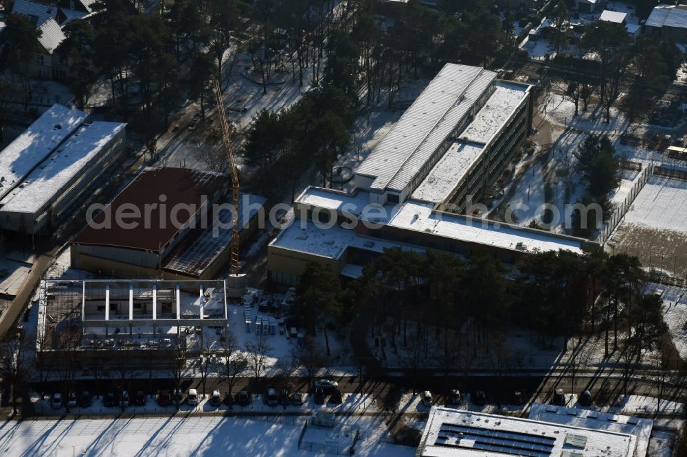 Aerial image Hohen Neuendorf - Winterly snowy construction site for the new building of aone-field sports hall on the Grunds of Marie-Curie-Gymnasium in Waldstrasse in Hohen Neuendorf in the state Brandenburg