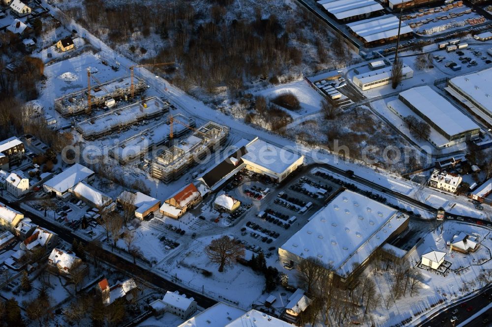 Berlin from the bird's eye view: Wintry snowy construction site to build a new multi-family residential complex An der Schule destrict Mahlsdorf in Berlin