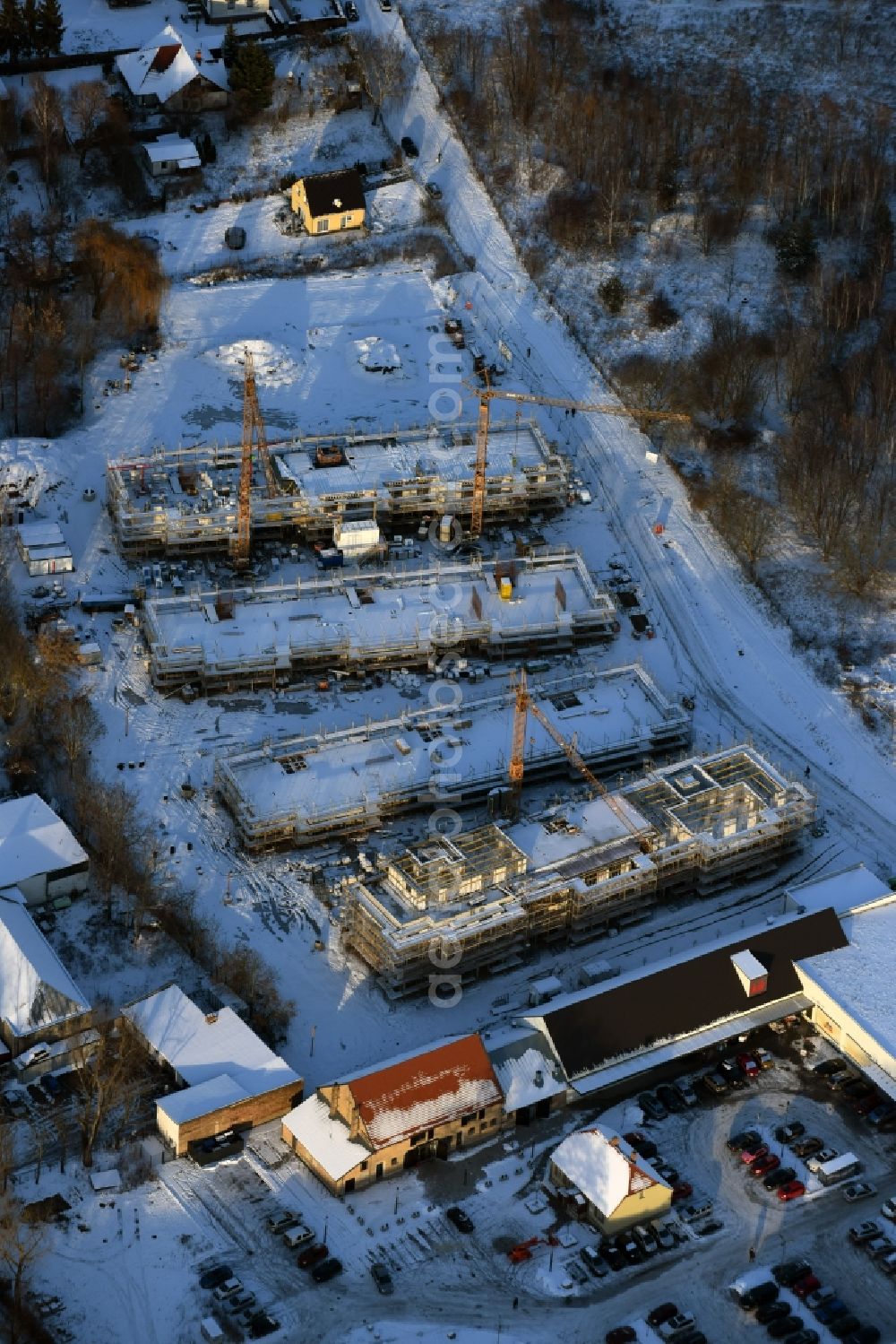 Berlin from the bird's eye view: Wintry snowy construction site to build a new multi-family residential complex An der Schule destrict Mahlsdorf in Berlin