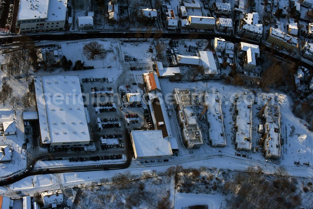 Berlin from the bird's eye view: Wintry snowy construction site to build a new multi-family residential complex An der Schule destrict Mahlsdorf in Berlin