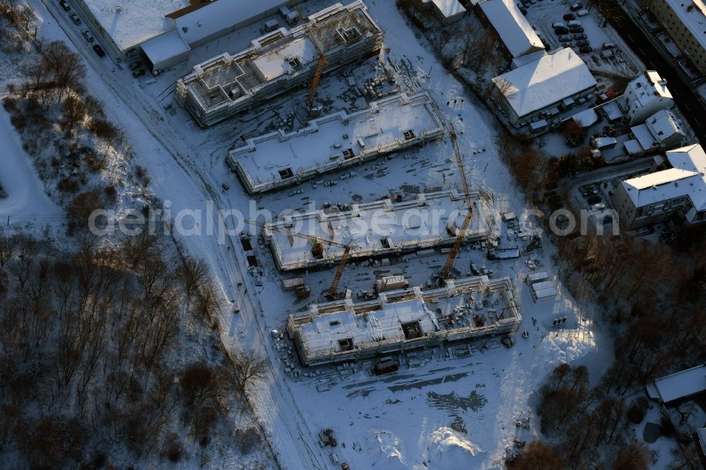 Berlin from the bird's eye view: Wintry snowy construction site to build a new multi-family residential complex An der Schule destrict Mahlsdorf in Berlin