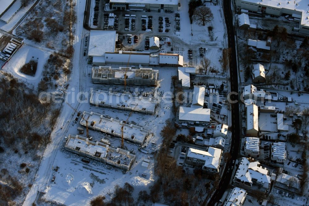 Berlin from above - Wintry snowy construction site to build a new multi-family residential complex An der Schule destrict Mahlsdorf in Berlin