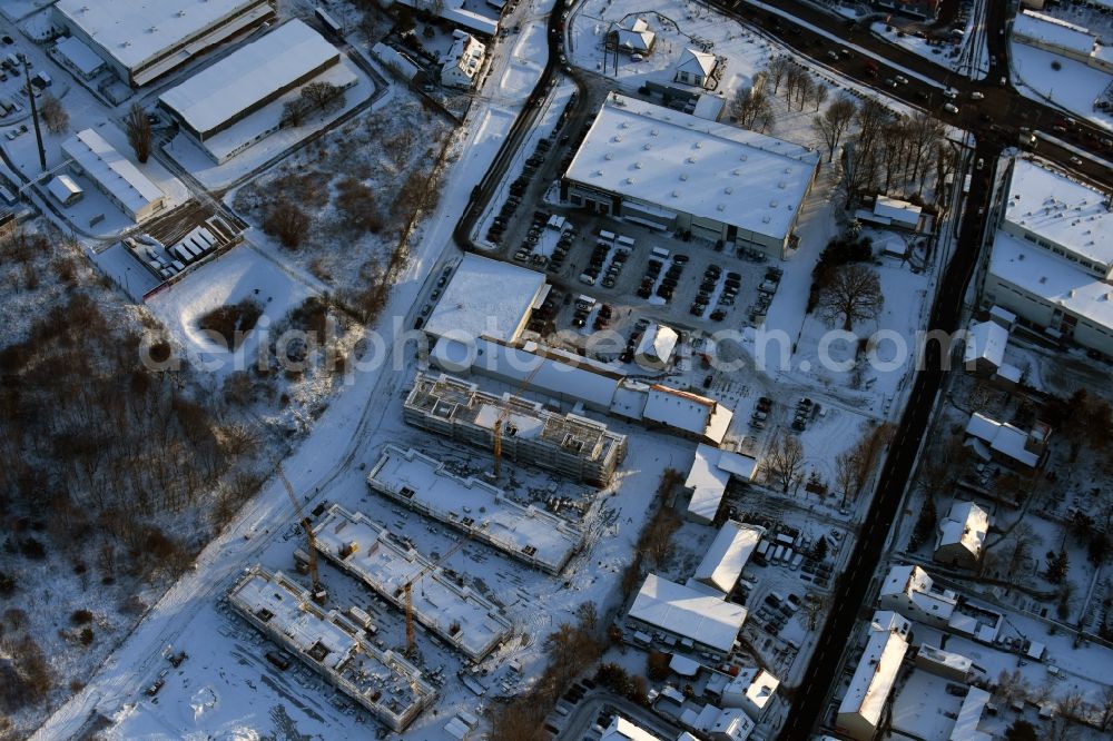 Berlin from the bird's eye view: Wintry snowy construction site to build a new multi-family residential complex An der Schule destrict Mahlsdorf in Berlin