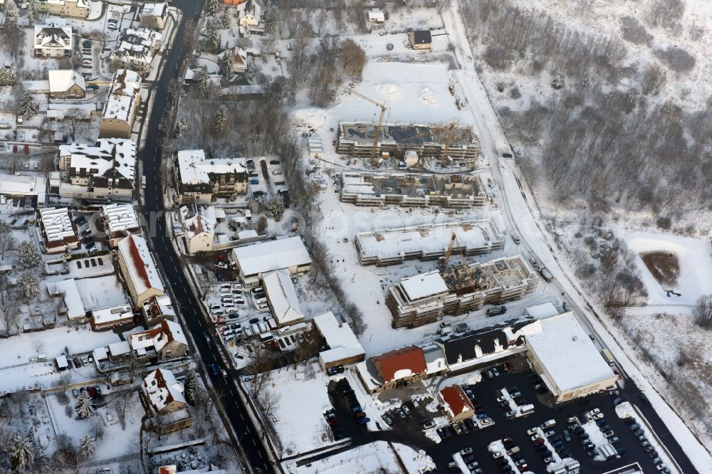 Berlin from above - Wintry snowy construction site to build a new multi-family residential complex An der Schule destrict Mahlsdorf in Berlin