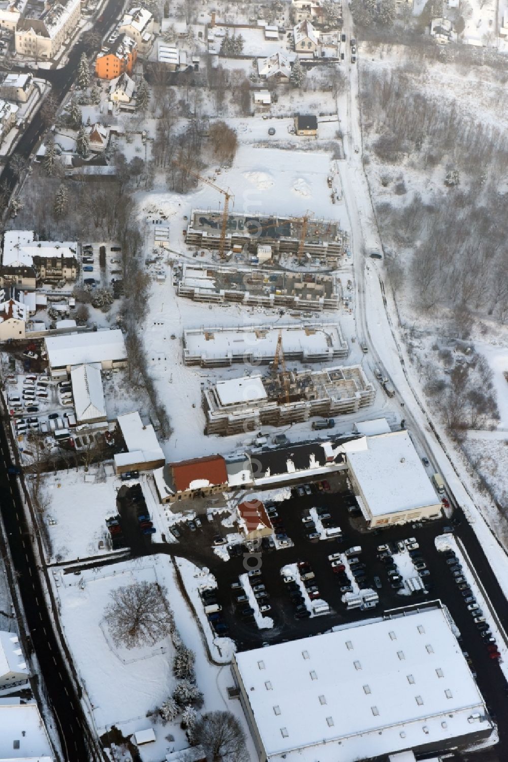 Berlin from the bird's eye view: Wintry snowy construction site to build a new multi-family residential complex An der Schule destrict Mahlsdorf in Berlin