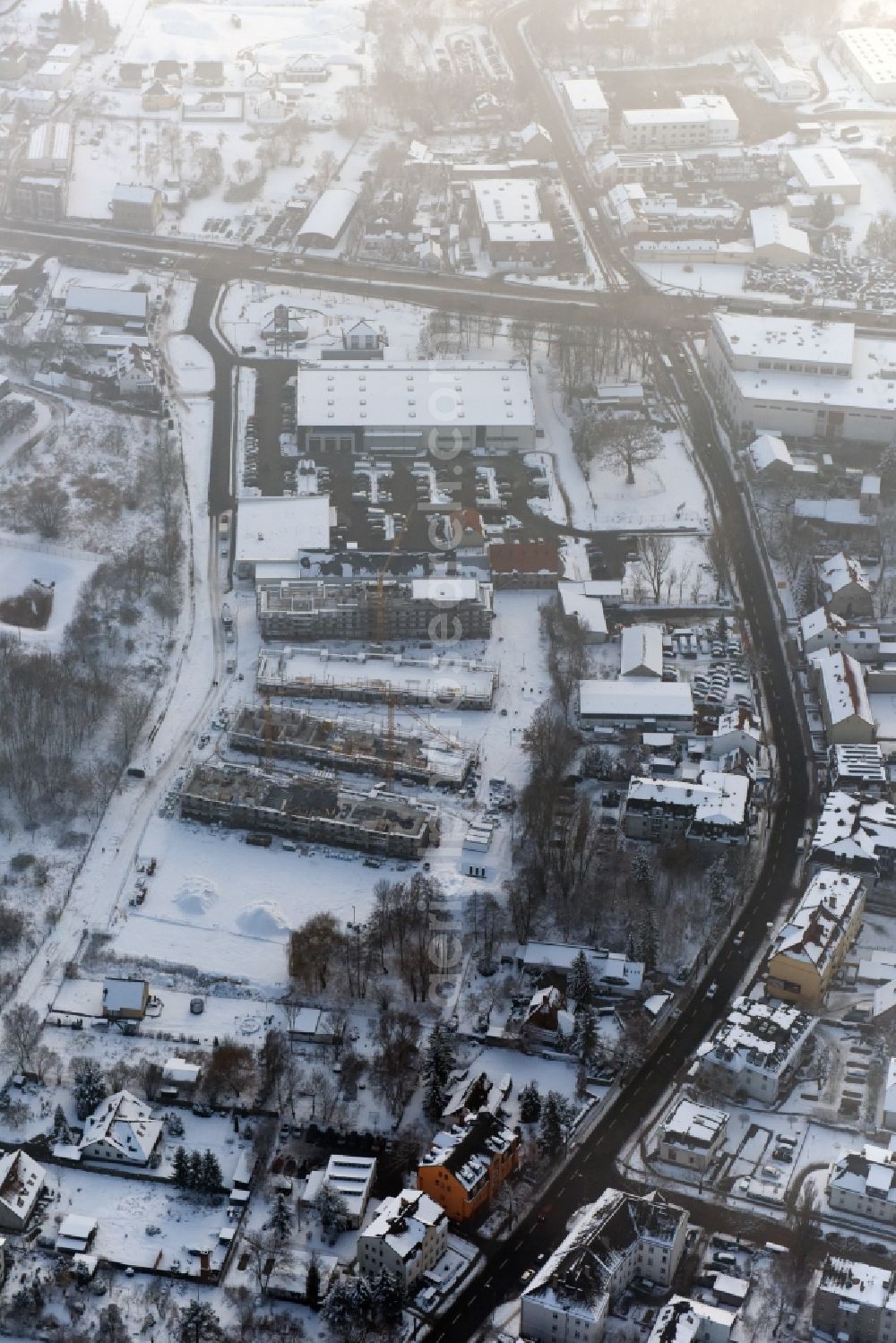 Berlin from above - Wintry snowy construction site to build a new multi-family residential complex An der Schule destrict Mahlsdorf in Berlin