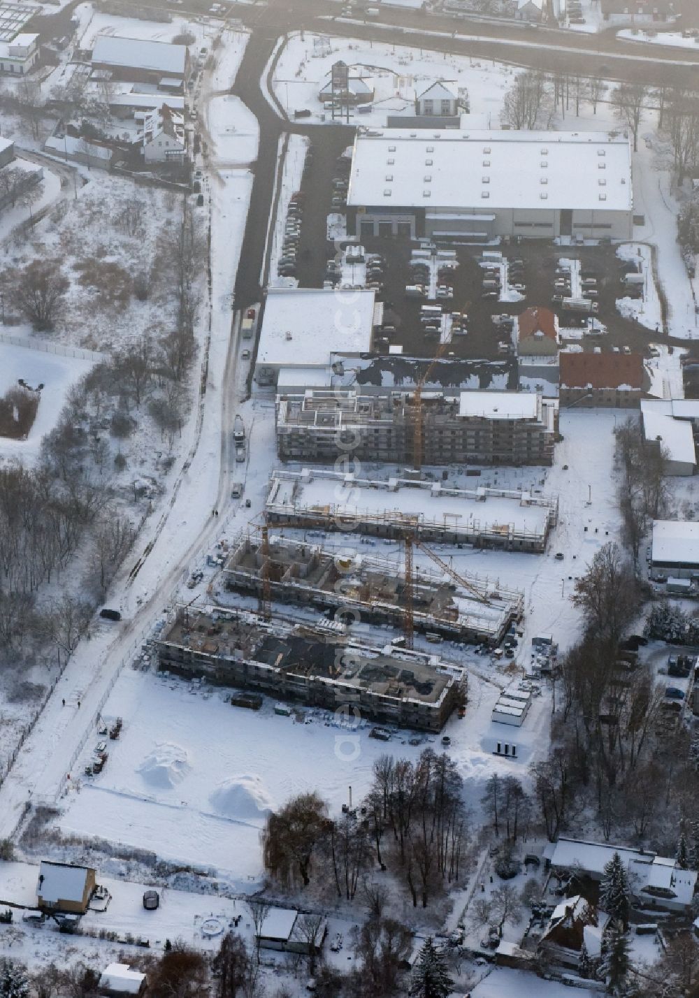 Berlin from the bird's eye view: Wintry snowy construction site to build a new multi-family residential complex An der Schule destrict Mahlsdorf in Berlin