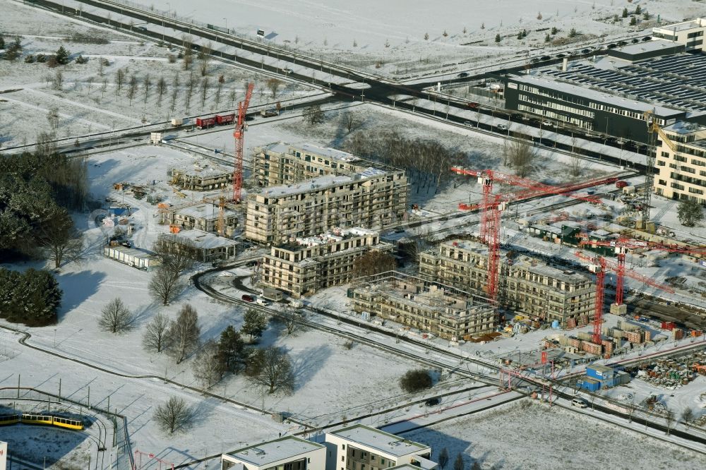 Berlin from above - Snow-covered construction site of a new multi-family residential complex „Wohnen am Campus“ on Wilhelm-Hoff-Strasse in the technology park Adlershof in Berlin in Germany