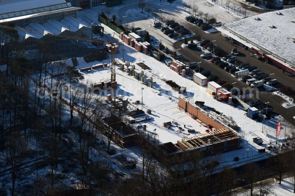 Hohen Neuendorf from above - Wintry snowy construction works of the shopping center at the former OBI - Hardware at Schoenfliesser street in Hohen Neuendorf in Brandenburg. GVG Project Development Company plans to revitalize the brain area by demolition of disused construction market and the new Spacious a modern local supply and service center