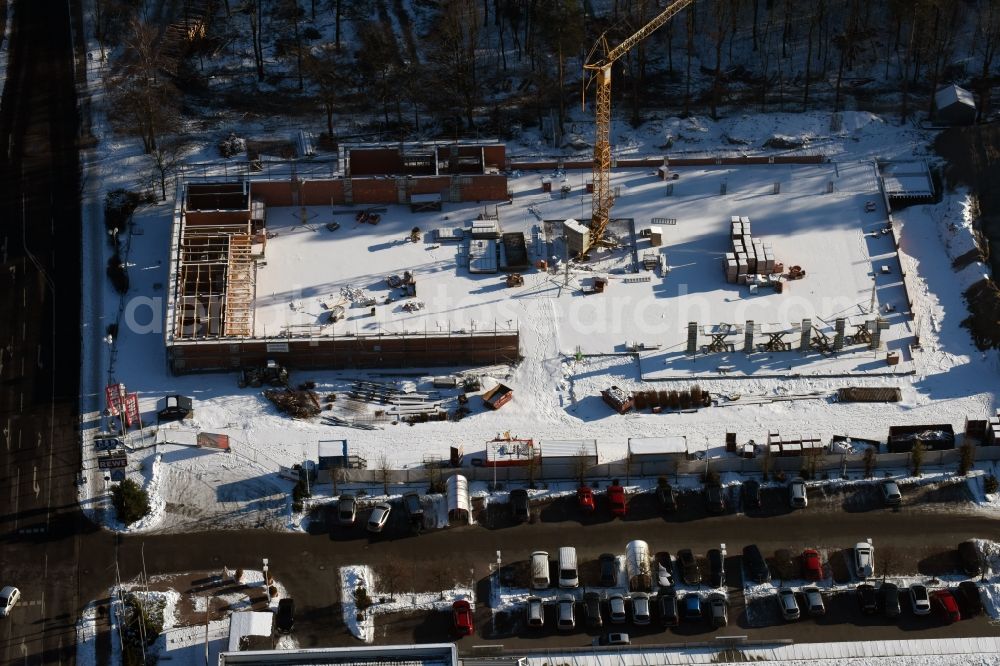 Aerial image Hohen Neuendorf - Wintry snowy construction works of the shopping center at the former OBI - Hardware at Schoenfliesser street in Hohen Neuendorf in Brandenburg. GVG Project Development Company plans to revitalize the brain area by demolition of disused construction market and the new Spacious a modern local supply and service center