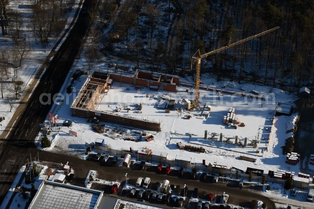 Aerial photograph Hohen Neuendorf - Wintry snowy construction works of the shopping center at the former OBI - Hardware at Schoenfliesser street in Hohen Neuendorf in Brandenburg. GVG Project Development Company plans to revitalize the brain area by demolition of disused construction market and the new Spacious a modern local supply and service center