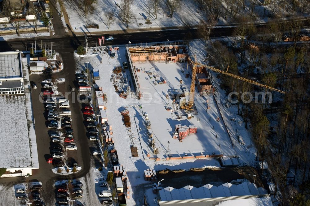 Hohen Neuendorf from above - Wintry snowy construction works of the shopping center at the former OBI - Hardware at Schoenfliesser street in Hohen Neuendorf in Brandenburg. GVG Project Development Company plans to revitalize the brain area by demolition of disused construction market and the new Spacious a modern local supply and service center