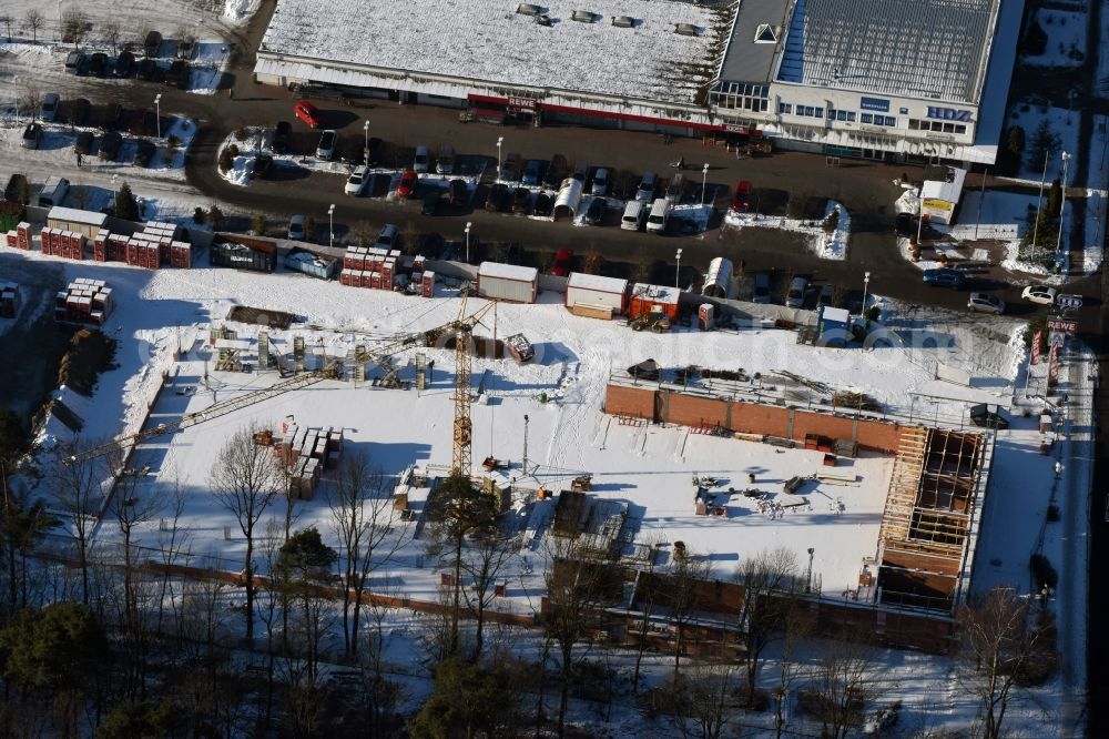 Aerial image Hohen Neuendorf - Wintry snowy construction works of the shopping center at the former OBI - Hardware at Schoenfliesser street in Hohen Neuendorf in Brandenburg. GVG Project Development Company plans to revitalize the brain area by demolition of disused construction market and the new Spacious a modern local supply and service center