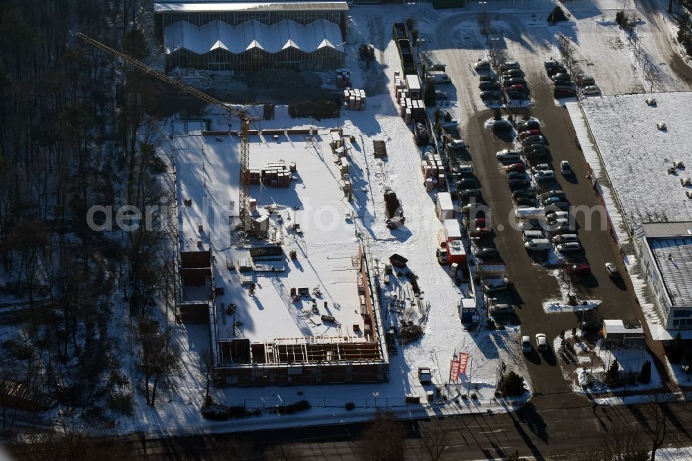 Aerial image Hohen Neuendorf - Wintry snowy construction works of the shopping center at the former OBI - Hardware at Schoenfliesser street in Hohen Neuendorf in Brandenburg. GVG Project Development Company plans to revitalize the brain area by demolition of disused construction market and the new Spacious a modern local supply and service center