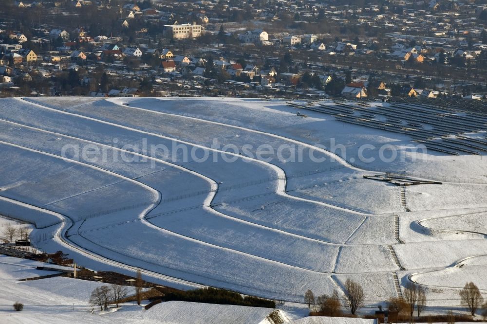 Aerial image Magdeburg - Wintry snowy piled landfill mountain of Solar Park Magdeburg in Saxony-Anhalt. Under the direction of the WSB Group of Companies of Magdeburg solar park was built on the former landfill site Cracauer Anger