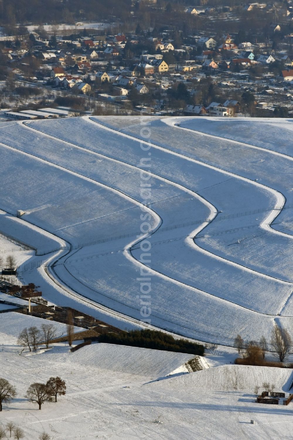 Magdeburg from the bird's eye view: Wintry snowy piled landfill mountain of Solar Park Magdeburg in Saxony-Anhalt. Under the direction of the WSB Group of Companies of Magdeburg solar park was built on the former landfill site Cracauer Anger