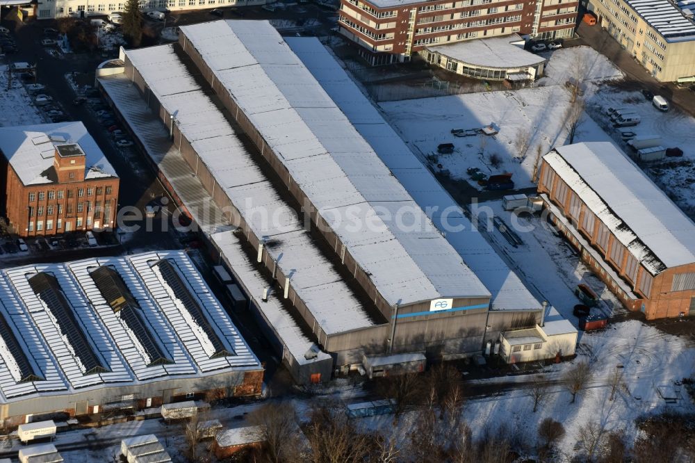 Magdeburg from above - Winterly snowy industrial area in the South of the Stadtfeld West part of Magdeburg in the state Saxony-Anhalt. The industrial and commerce area includes different companies and workshops with halls, factoriy buidlings and company compounds of different sizes. View of the hall of Armacon Systems GmbH as well as the independent garage VEW Autodienst GmbH