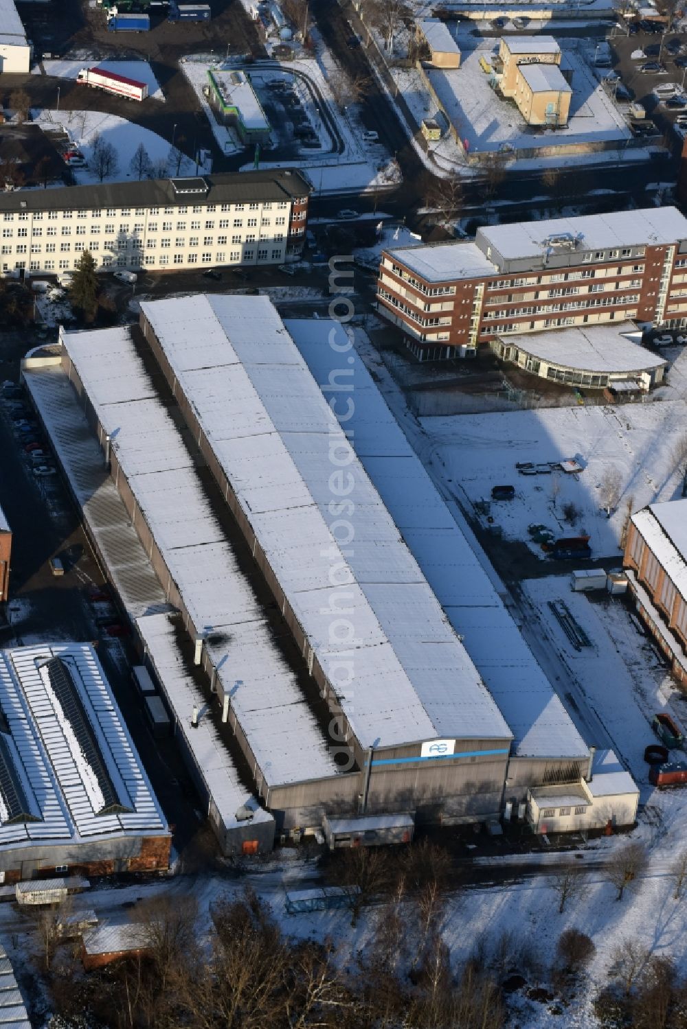 Magdeburg from the bird's eye view: Winterly snowy industrial area in the South of the Stadtfeld West part of Magdeburg in the state Saxony-Anhalt. The industrial and commerce area includes different companies and workshops with halls, factoriy buidlings and company compounds of different sizes. View of the hall of Armacon Systems GmbH as well as the independent garage VEW Autodienst GmbH