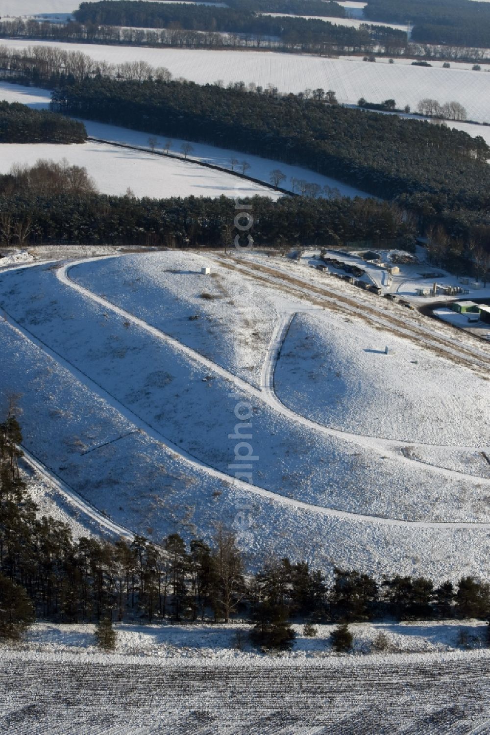 Elbe-Parey from the bird's eye view: Wintry snow-covered site of the heaped landfill Werderberg in Elbe-Parey in the state of Saxony-Anhalt. The landfill is part of Abfallwirtschaftsgesellschaft Jerichower Land mbH (the county waste management company) and is located between Elbe-Parey and the village of Bergzow