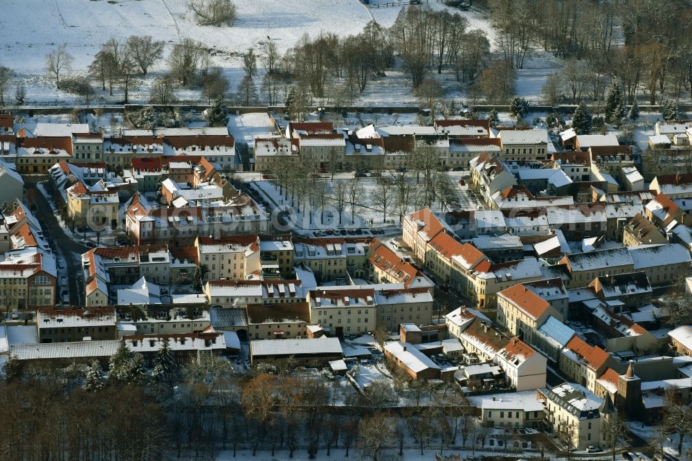 Altlandsberg from the bird's eye view: Wintry snowy townscape with streets and houses of the residential areas in Altlandsberg in the state Brandenburg