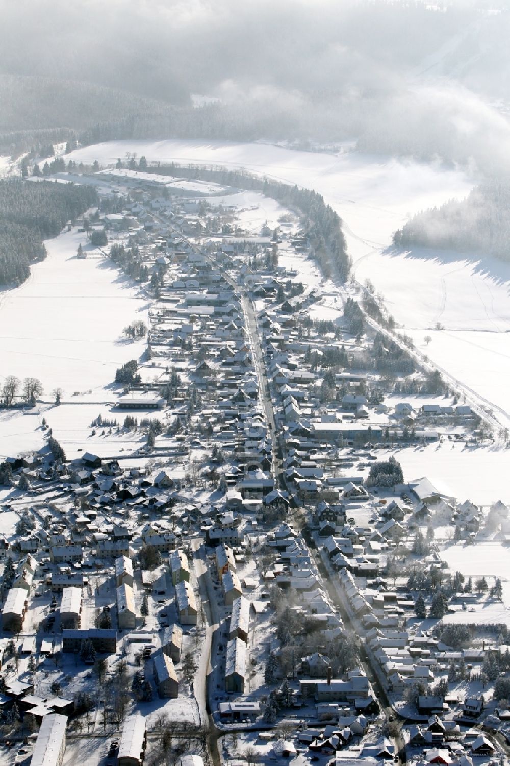 Aerial image Neuhaus am Rennweg - Wintry snowy townscape with streets and houses of the residential areas in Neuhaus am Rennweg in the state Thuringia