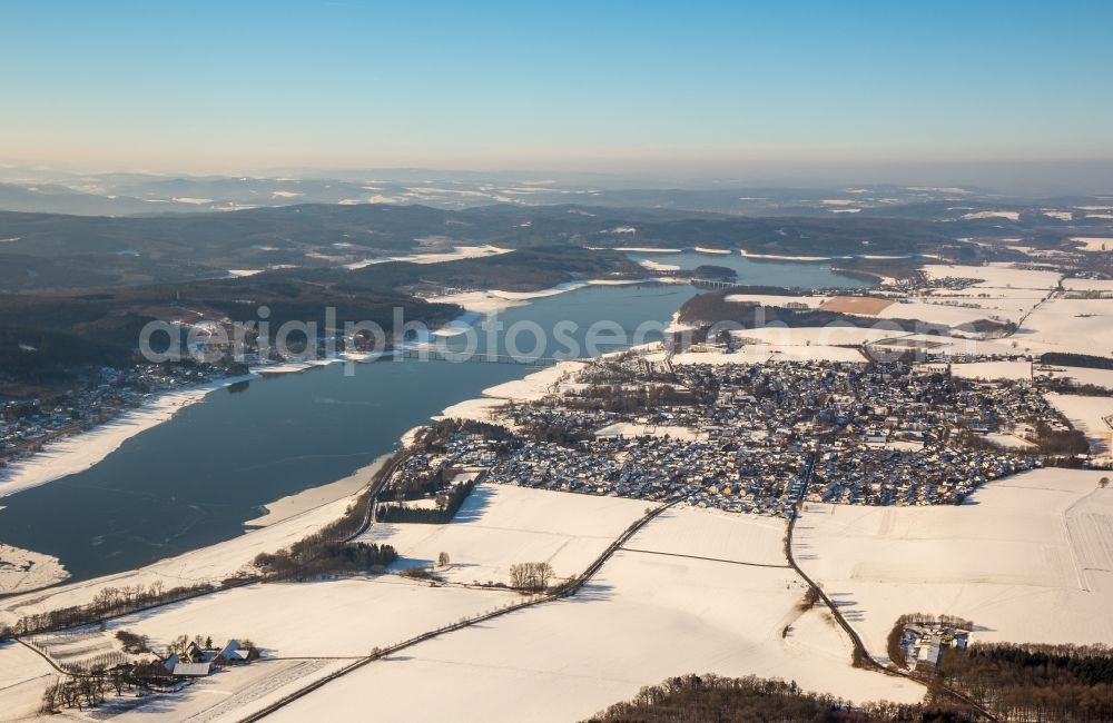 Aerial image Möhnesee - Wintry snowy townscape with streets and houses of the residential areas in the district Koerbecke at the Moehne lake in Moehnesee in the state North Rhine-Westphalia