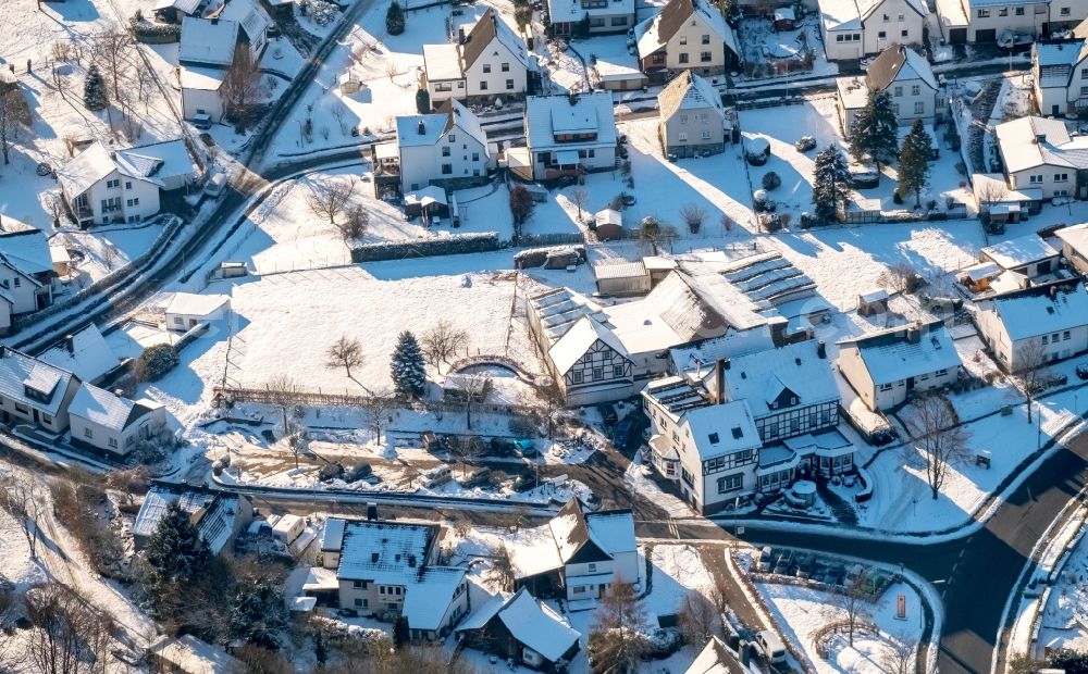 Arnsberg from the bird's eye view: Wintry snowy townscape with streets and houses of the residential areas in the district Rumbeck in Arnsberg in the state North Rhine-Westphalia