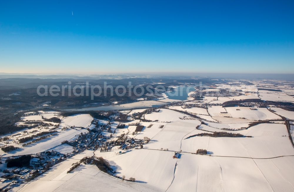 Möhnesee from above - Wintry snowy townscape with streets and houses of the residential areas in the district Wamel near the river Moehn in Moehnesee in the state North Rhine-Westphalia