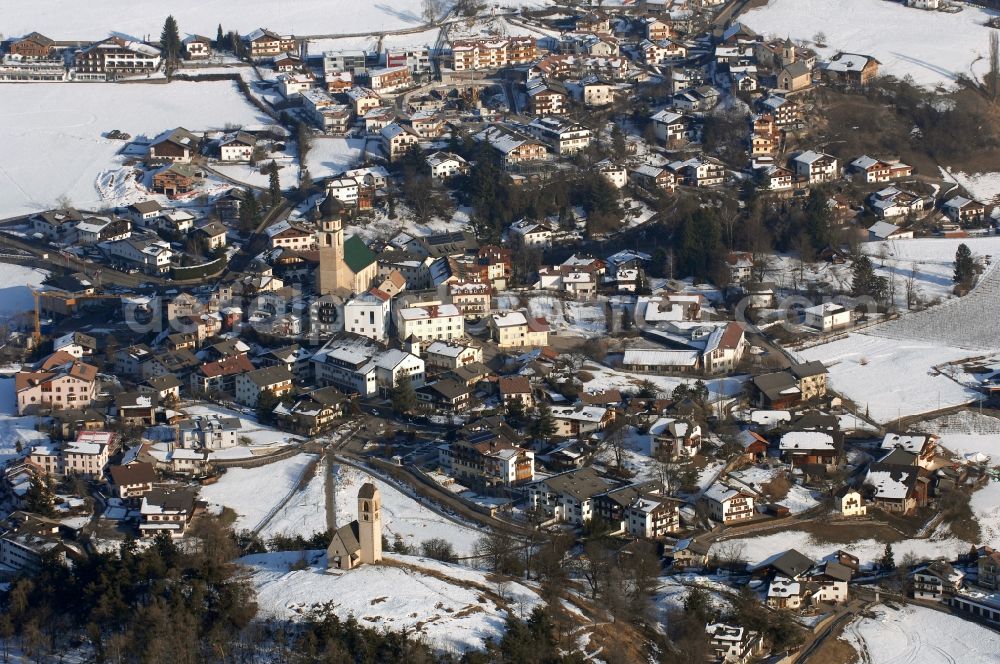 Völs am Schlern - Fié allo Sciliar from the bird's eye view: Wintry snowy townscape with streets and houses of the residential areas in Voels am Schlern - Fie allo Sciliar in Trentino-Alto Adige, Italy