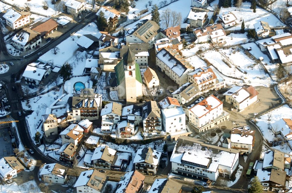 Völs am Schlern - Fié allo Sciliar from the bird's eye view: Wintry snowy townscape with streets and houses of the residential areas in Voels am Schlern - Fie allo Sciliar in Trentino-Alto Adige, Italy