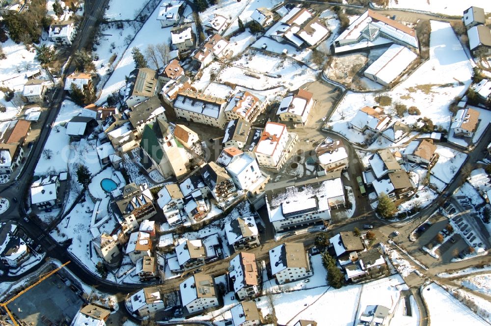 Völs am Schlern - Fié allo Sciliar from the bird's eye view: Wintry snowy townscape with streets and houses of the residential areas in Voels am Schlern - Fie allo Sciliar in Trentino-Alto Adige, Italy