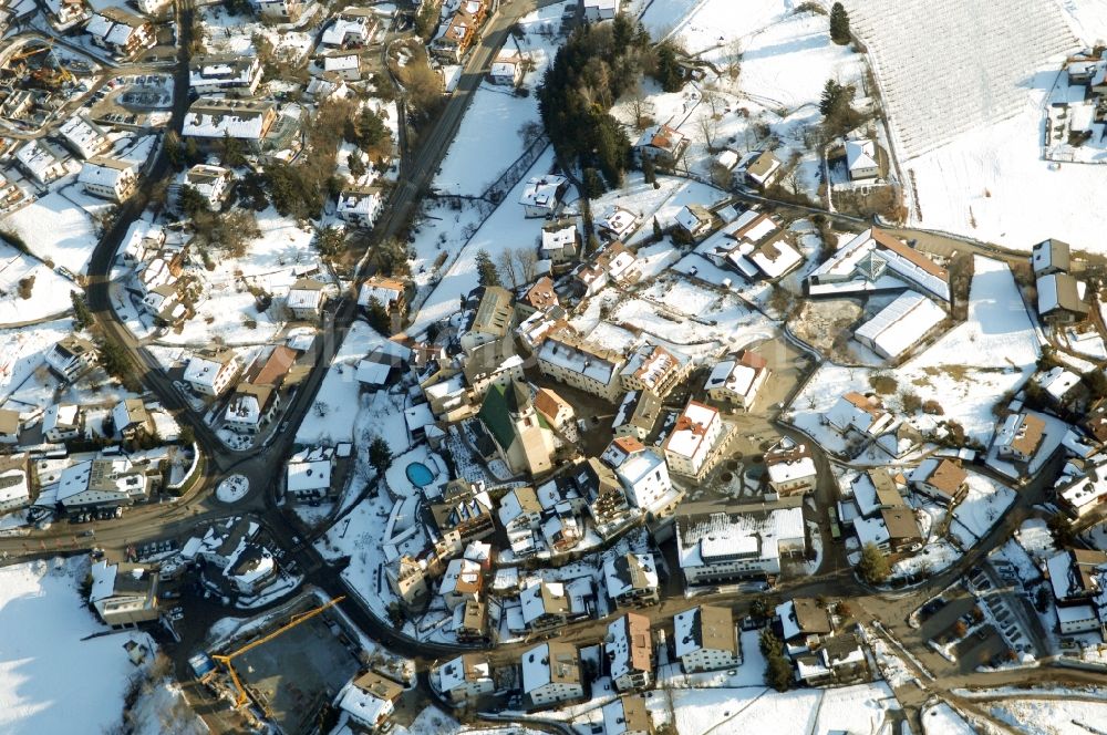 Völs am Schlern - Fié allo Sciliar from the bird's eye view: Wintry snowy townscape with streets and houses of the residential areas in Voels am Schlern - Fie allo Sciliar in Trentino-Alto Adige, Italy