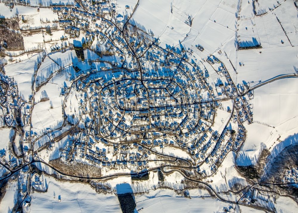 Warstein from the bird's eye view: Wintry snowy townscape with streets and houses of the residential areas in Warstein in the state North Rhine-Westphalia