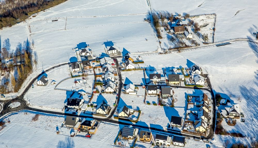 Aerial photograph Arnsberg - Wintry snowy district view in the traffic of a circle Wiggenscheid and town break in the district rum baker in Arnsberg in the federal state North Rhine-Westphalia