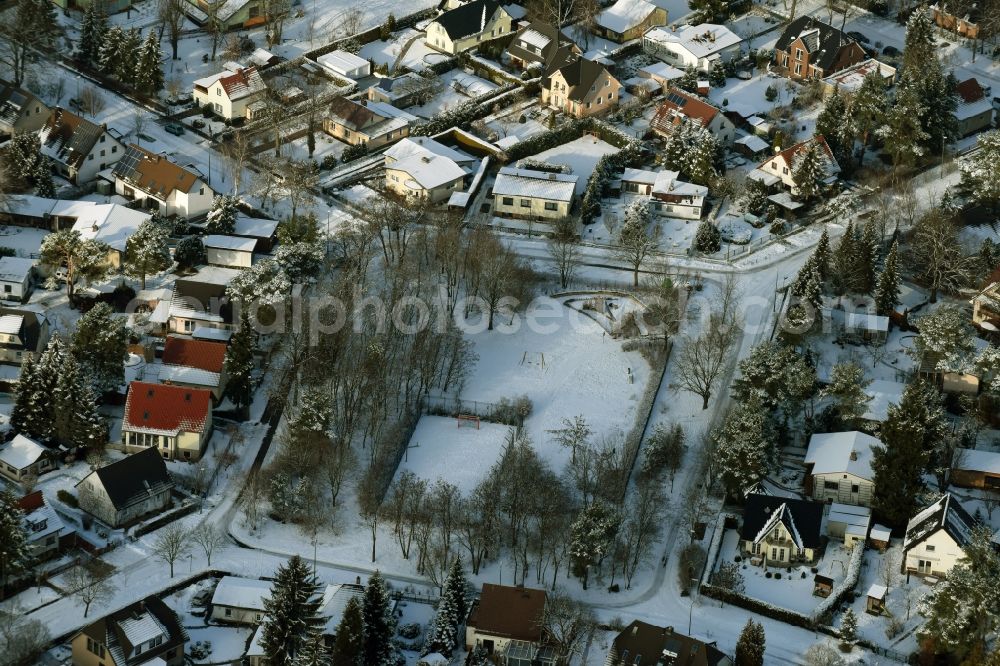 Aerial image Berlin - Winterly snowy park with playground in Ifflandstrasse, Langenbeckstrasse, Spitzwegstrasse and Zipser Weg midst a residential area in Berlin in Germany