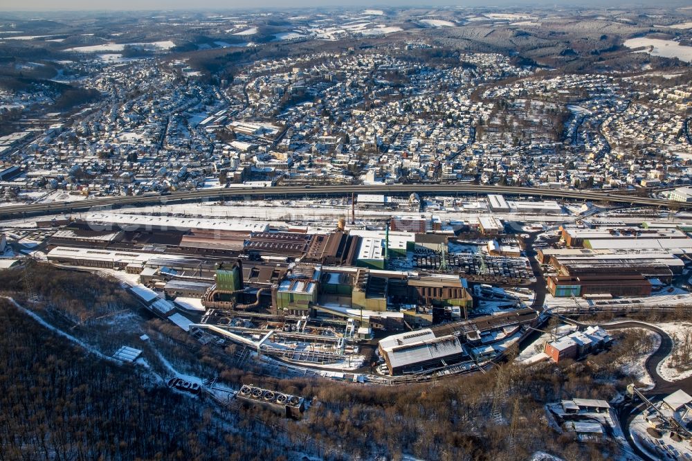 Siegen from the bird's eye view: Winterly snowy technical equipment and production facilities of the steelworks Deutsche Edelstahlwerke GmbH along the road Huetteltalstrasse B54 in Siegen in the state North Rhine-Westphalia