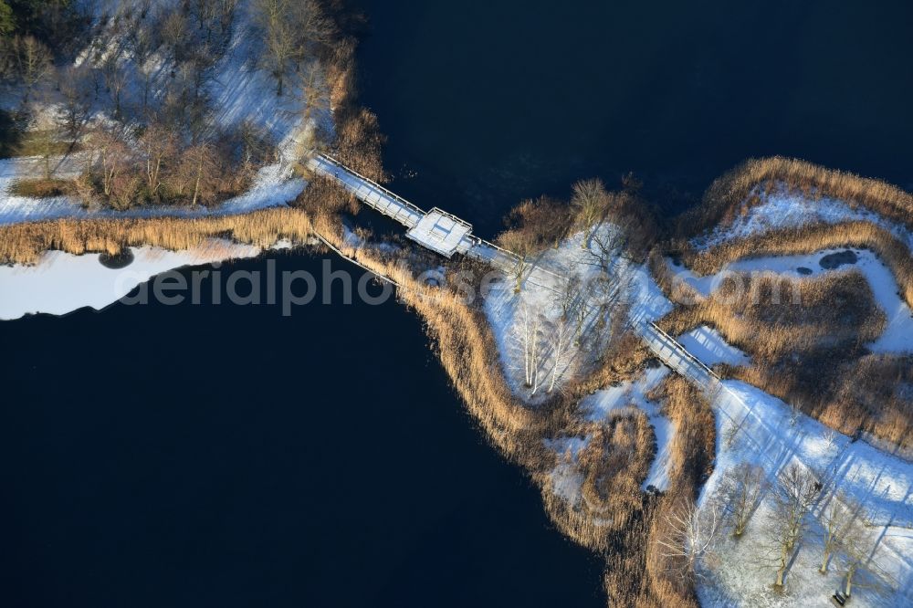 Berlin from above - Wintry snowy lake area of Hauptsee in the recreation park Britz Garden in Berlin, Germany