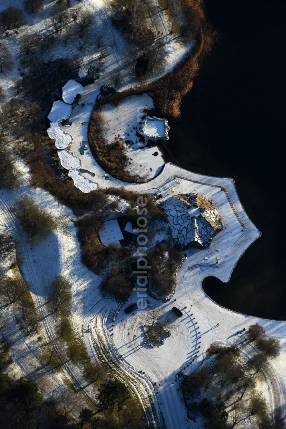 Berlin from the bird's eye view: Wintry snowy lake area of Hauptsee in the recreation park Britz Garden in Berlin, Germany