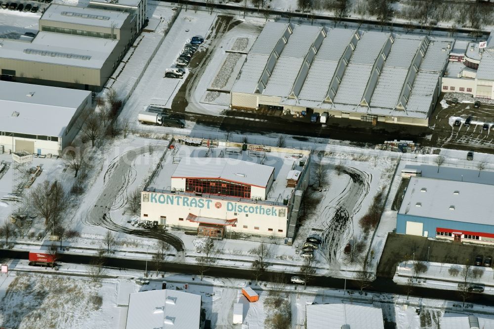 Hoppegarten from the bird's eye view: Winterly snowy building of the indoor arena Kontraste Hochzeitssalon in Hoppegarten in the state Brandenburg. This indoor arena was formerly a disco