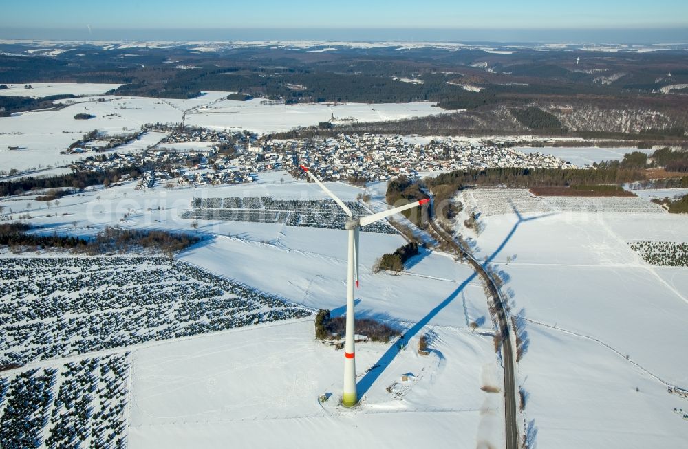 Brilon from the bird's eye view: Wintry snowy wind turbine windmill on a field in Brilon in the state North Rhine-Westphalia