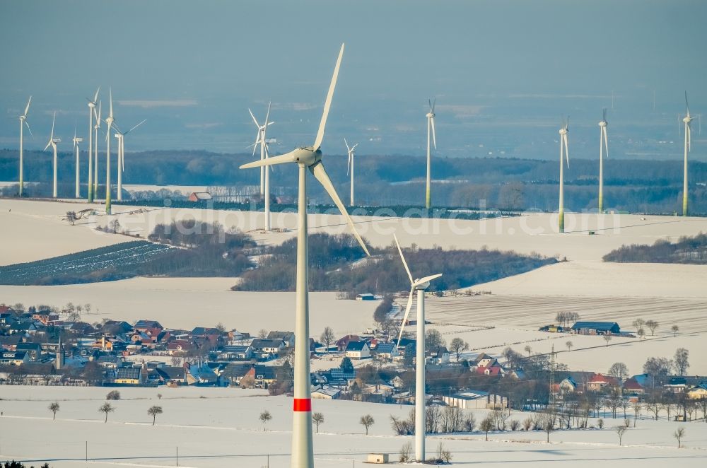 Rüthen from the bird's eye view: Wintry snowy wind turbine windmills on a field in Ruethen in the state North Rhine-Westphalia