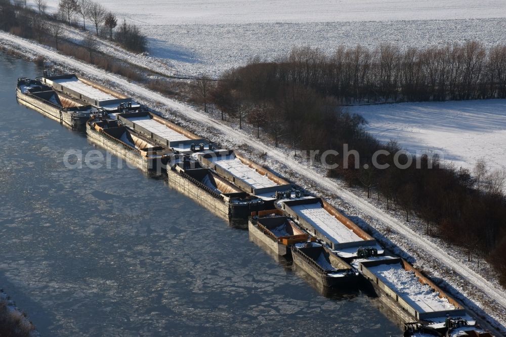 Burg from above - Wintry snowy channel course with moored barge inland thrust units on the banks of the Elbe-Havel Canal in Burg in Saxony-Anhalt