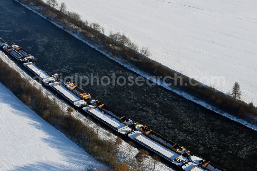 Burg from the bird's eye view: Wintry snowy channel course with moored barge inland thrust units on the banks of the Elbe-Havel Canal in Burg in Saxony-Anhalt