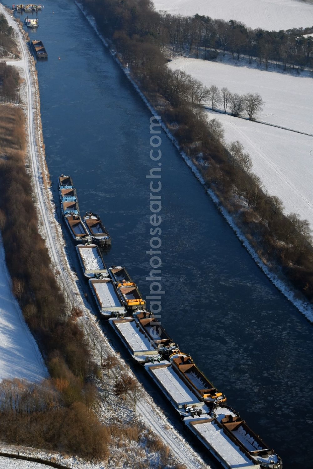 Aerial image Burg - Wintry snowy channel course with moored barge inland thrust units on the banks of the Elbe-Havel Canal in Burg in Saxony-Anhalt