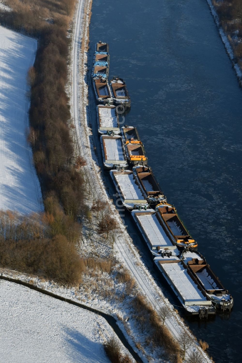 Burg from above - Wintry snowy channel course with moored barge inland thrust units on the banks of the Elbe-Havel Canal in Burg in Saxony-Anhalt