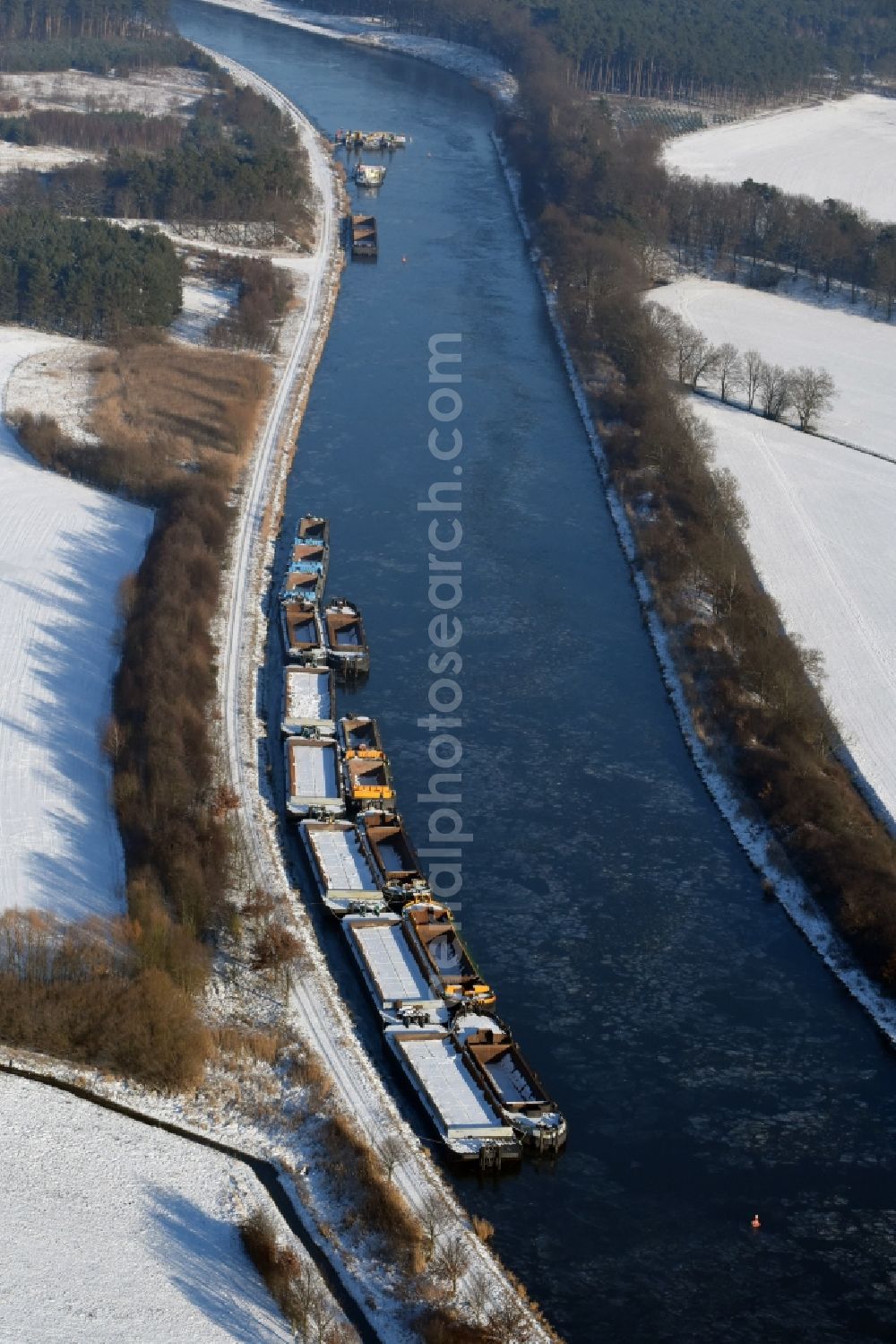 Burg from the bird's eye view: Wintry snowy channel course with moored barge inland thrust units on the banks of the Elbe-Havel Canal in Burg in Saxony-Anhalt