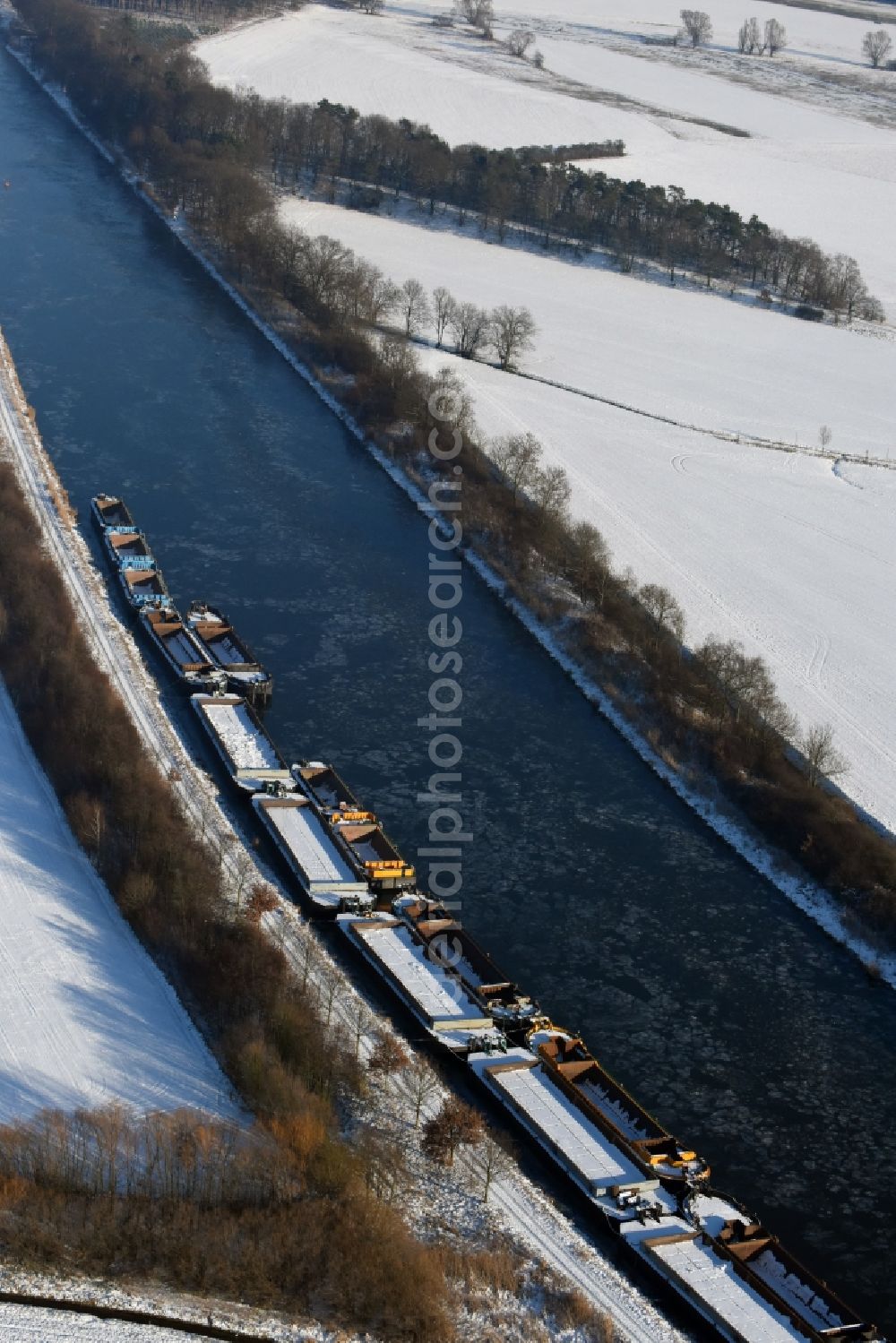 Burg from above - Wintry snowy channel course with moored barge inland thrust units on the banks of the Elbe-Havel Canal in Burg in Saxony-Anhalt